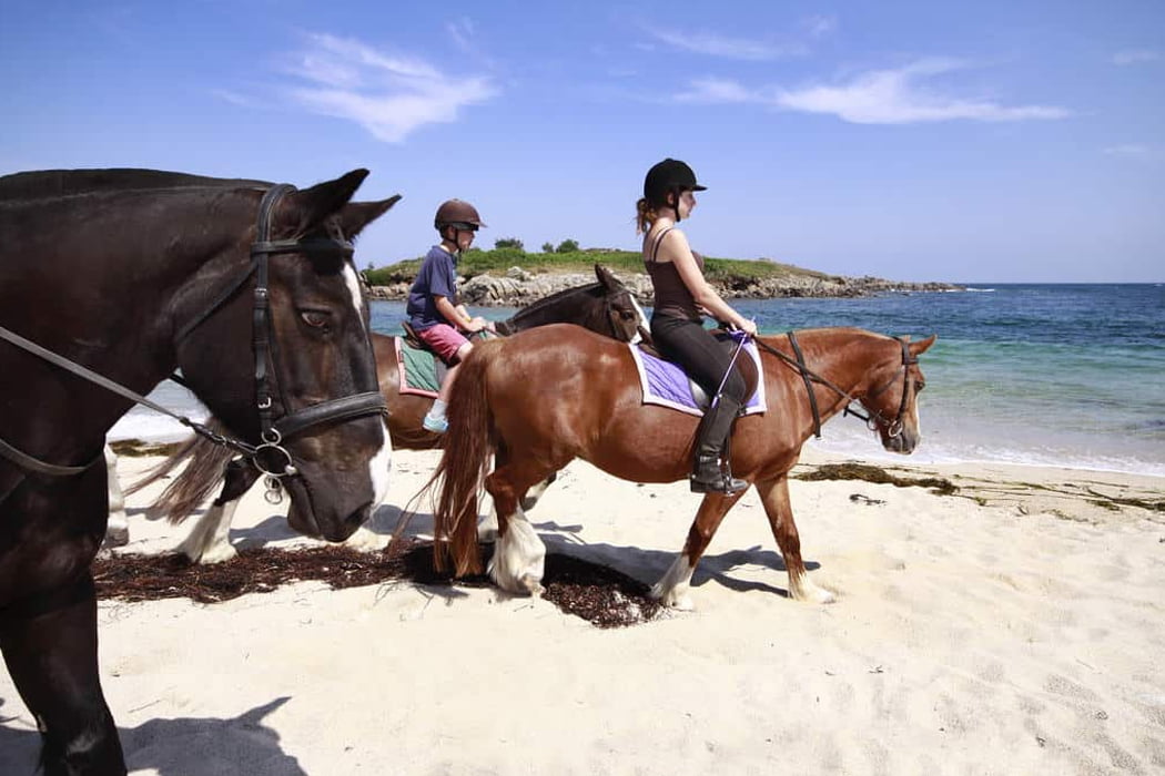 Horse riding group enjoying riding on the beach, St Mary's, Isles of Scilly