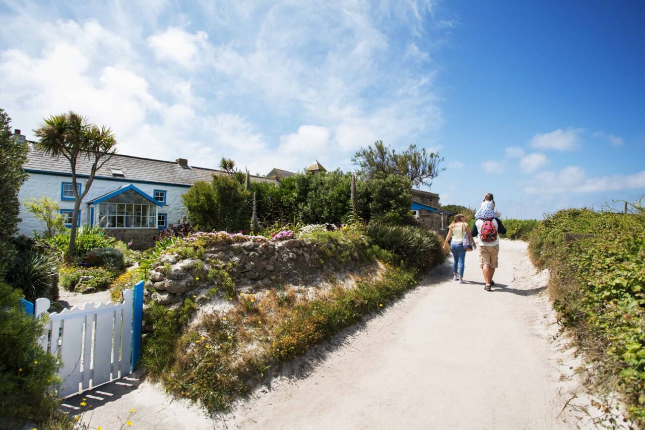 Family walking past a self-catering-cottage on the Isles of Scilly