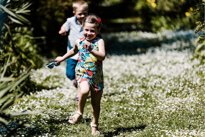 Children running down a daisy path on St Mary's, Isles of Scilly