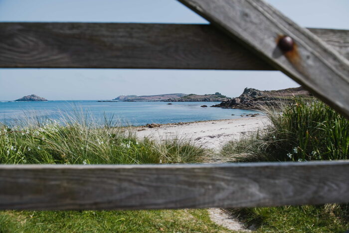 Spring beach view of Tresco through a wooden gate