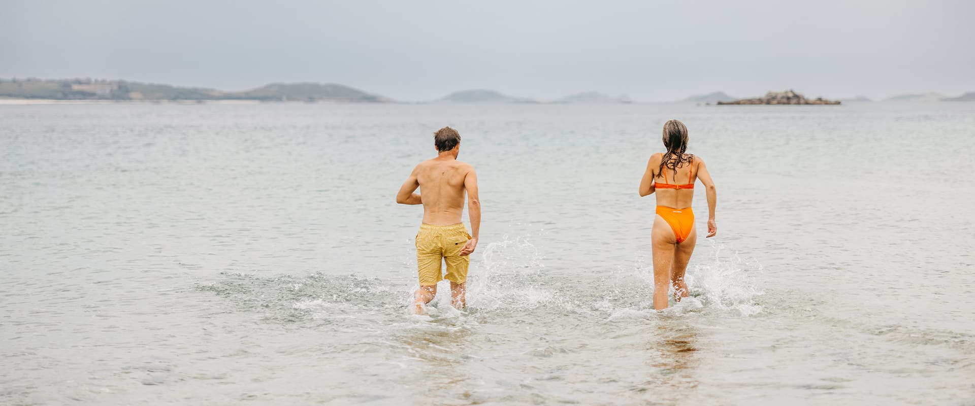 Couple going wild swimming, pentle bay, tresco, Isles of Scilly