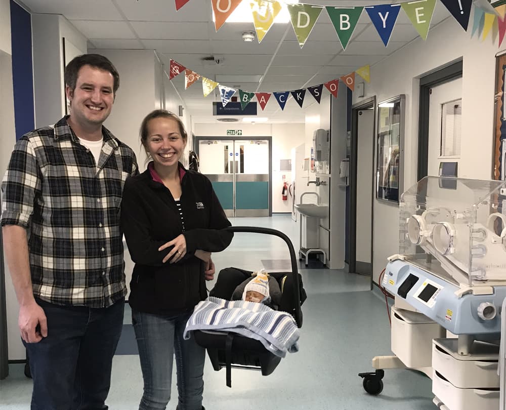 parents bringing their premature baby home from hospital