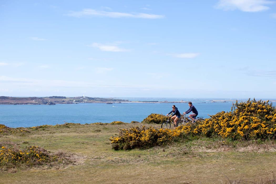 Couple cycling the coastal path St Mary's 