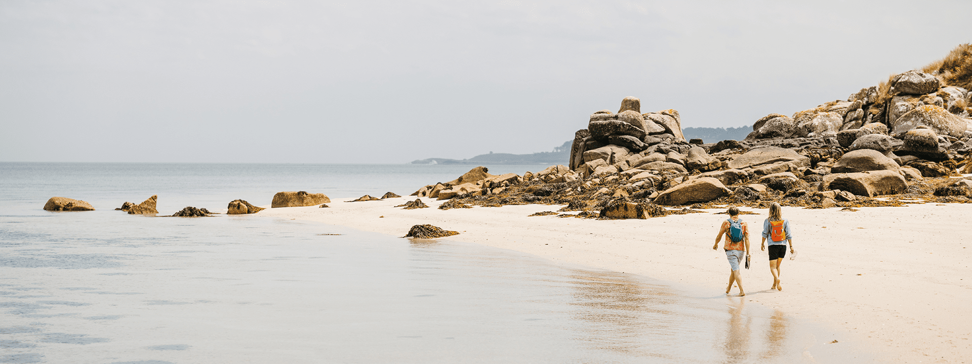 Couple walking on a quiet beach - Tresco, Isles of Scilly