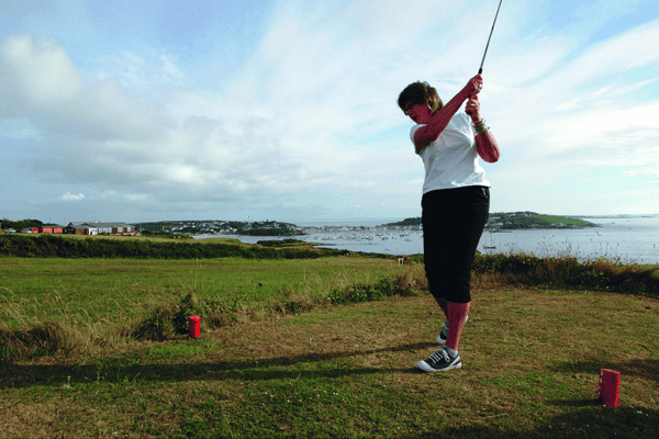 Woman playing golf on the Isles of Scilly Golf Course, St Mary's