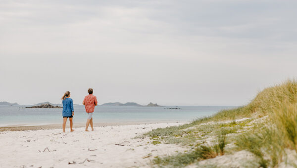 Two people walking along a beach