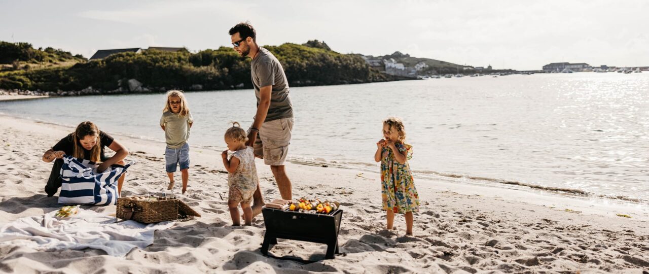Family enjoying a beach barbecue  on porthmellon beach, st mary's, Isles of Scilly