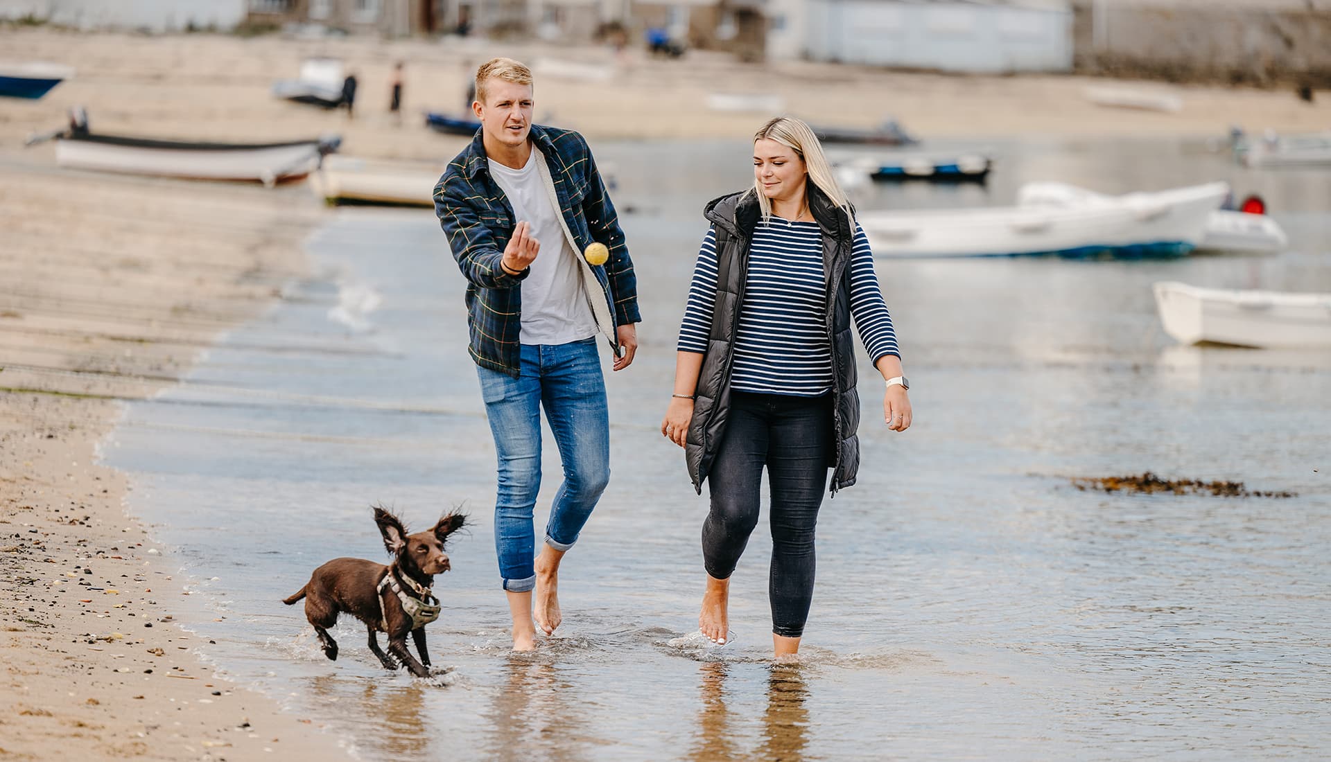 Couple playing ball with their dog along Town Beach, St Mary's - Isles of Scilly