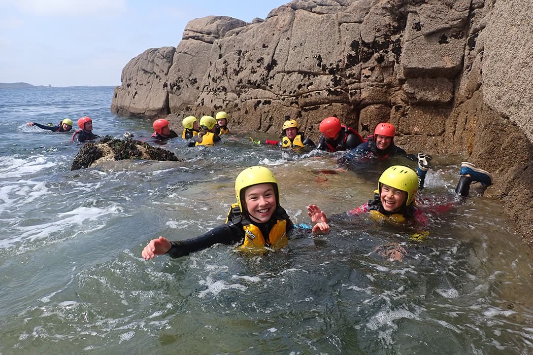 a group of people on a coasteering tour swimming, Peninnis head, St Marys