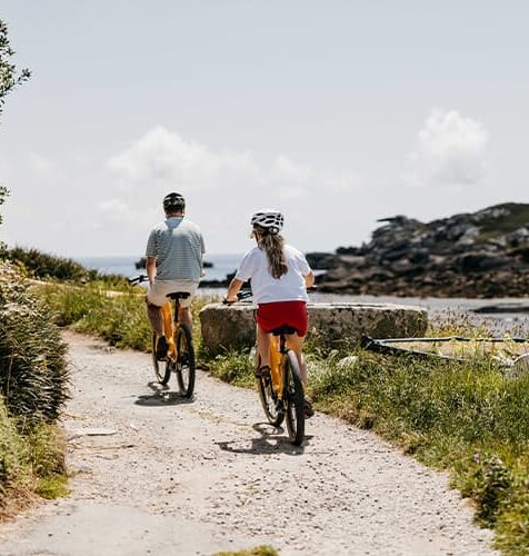 Couple cycling on bikes - Old Town, St Mary's, Isles of Scilly