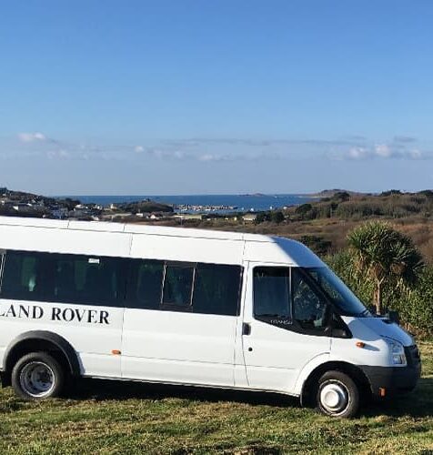 Island Rover mini bus in front of a view over St Mary's, Isles of Scilly
