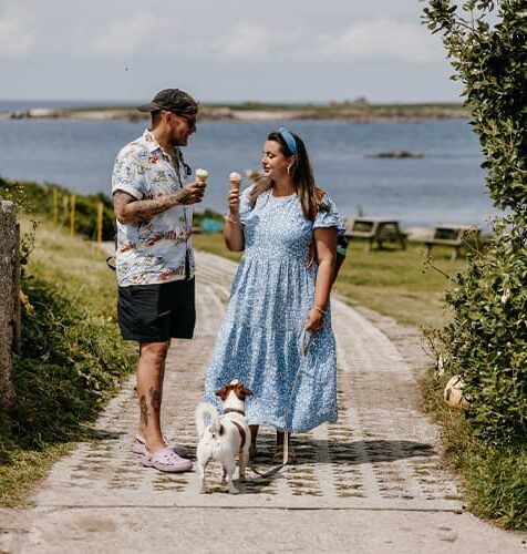 a couple with their dog, eating ice cream from Troytown Farm, St Agnes, Isles of Scilly
