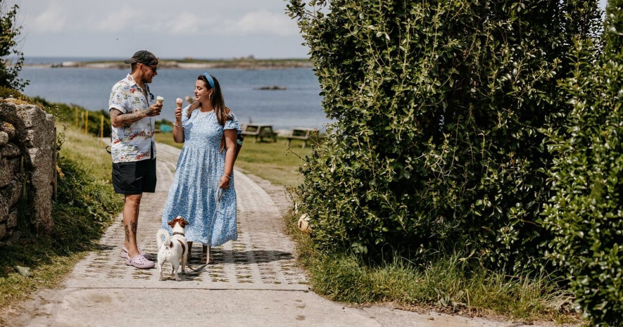 a couple with their dog, eating ice cream from Troytown Farm, St Agnes, Isles of Scilly
