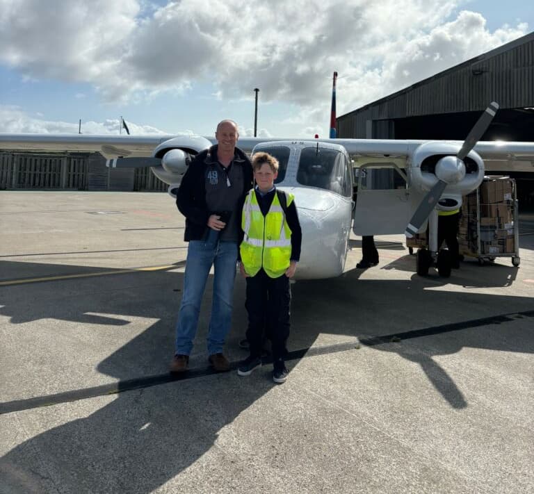 Harry and his Dad standing infront of a SKybus Islander freighter at Land's End Airport