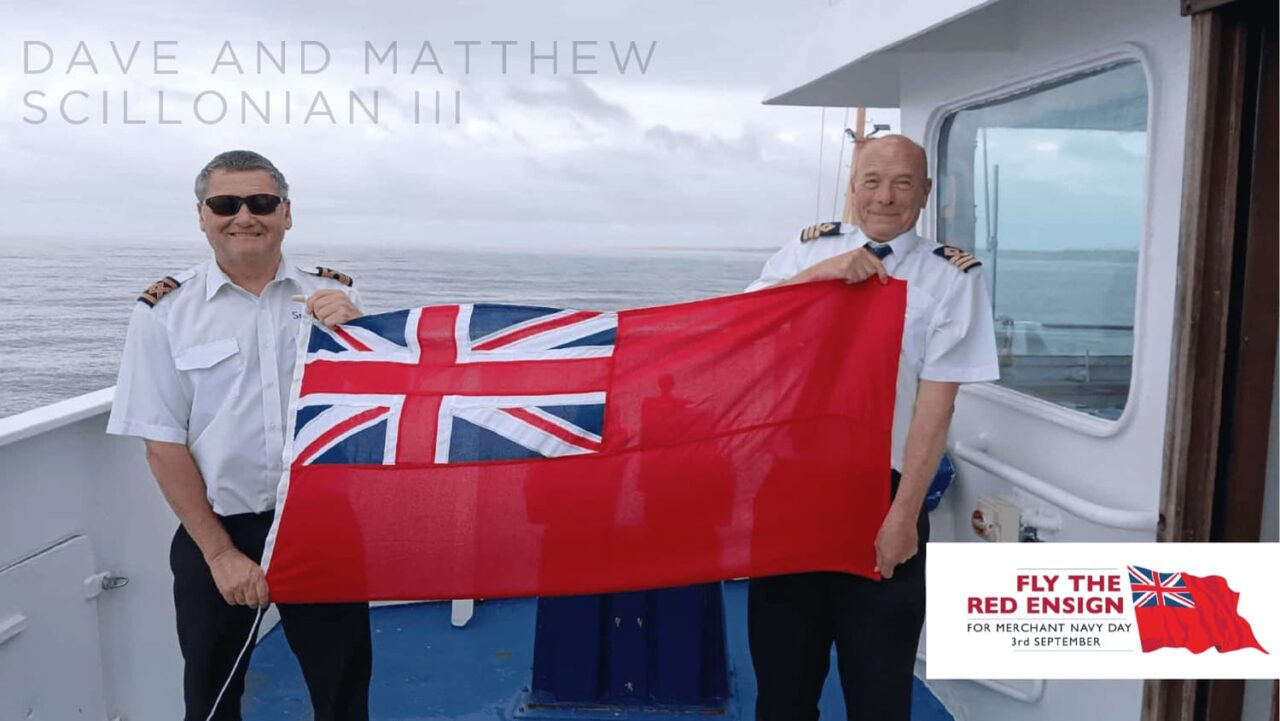 David and Matthew holding the British red ensign flag on baord Scillonian III