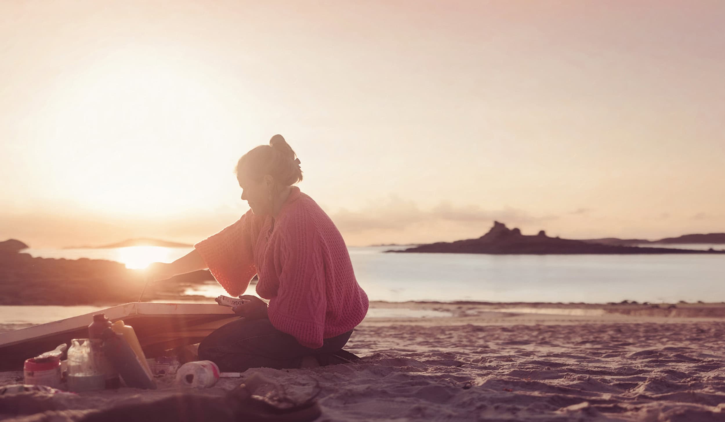 Artist Emily Powell, painting a sunset on Porthloo Beach, St Mary's - Isles of Scilly