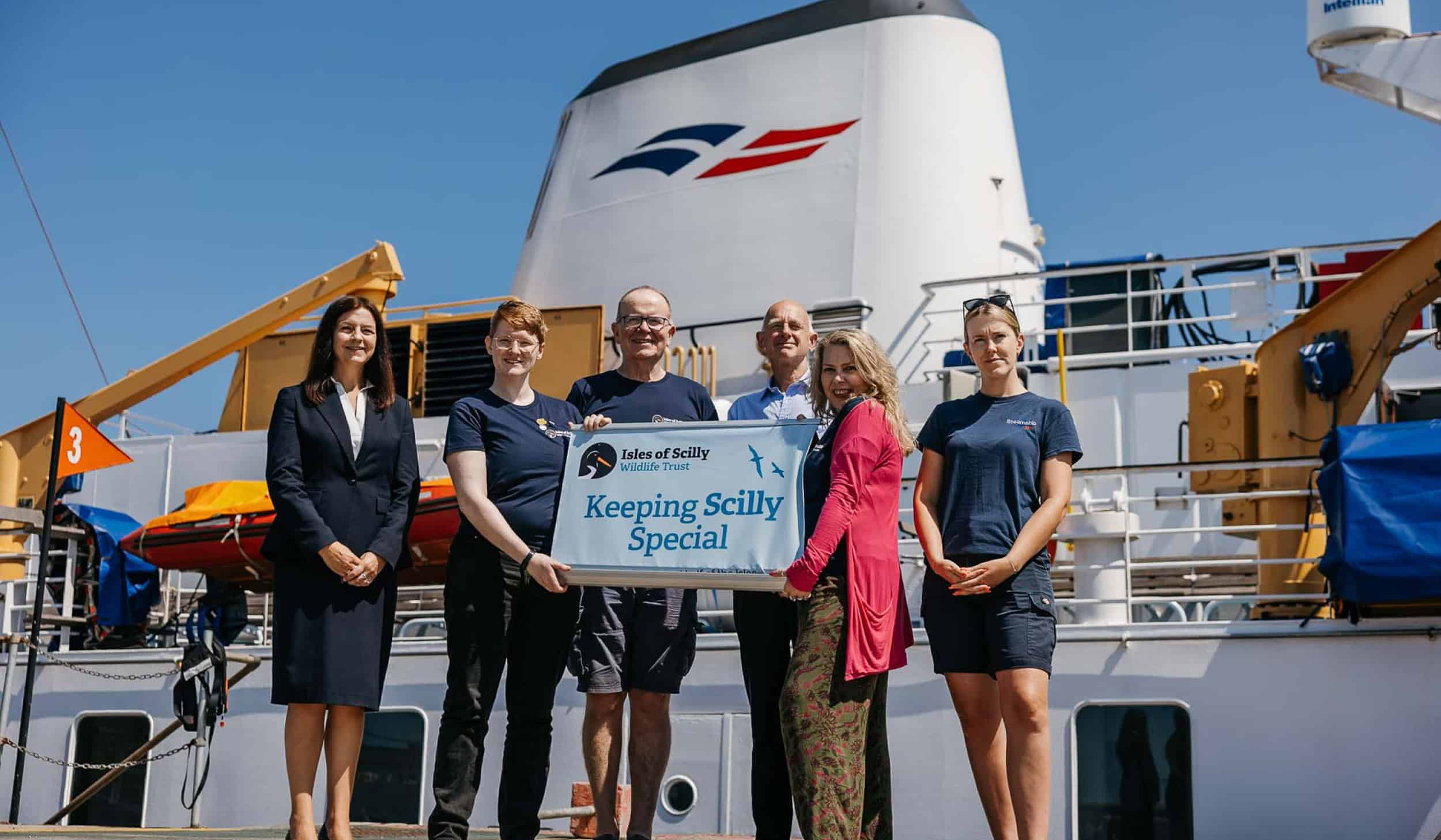 Isles of scilly steamship group and isles of scilly wildlife trust teams standing in front of Scillonian III
