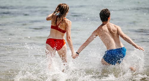 Couple splashing about in the sea, Isles of Scilly