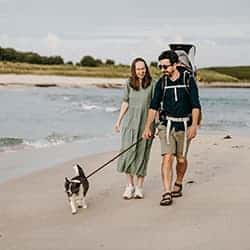 Family walking their dog along The Bar, St Agnes, Isles of Scilly