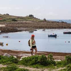 Lydia Cooke walking along a beach, St Agnes, Isles of Scilly