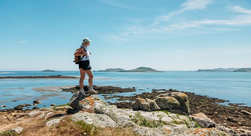 woman walking along a costal route, St Martin's, Isles of Scilly