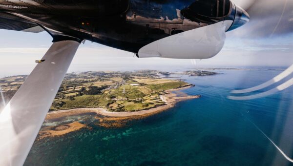 Aerial shot of Isles of Scilly and the wing of a Skybus plane