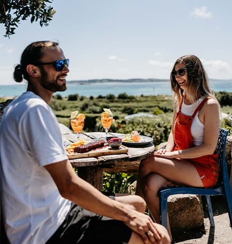 Friends enjoying lunch outside at Seven stones inn, St Martin's, Isles of Scilly