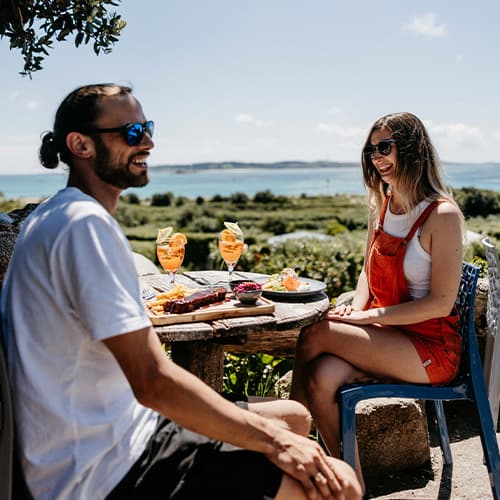 Friends enjoying lunch outside at Seven stones inn, St Martin's, Isles of Scilly