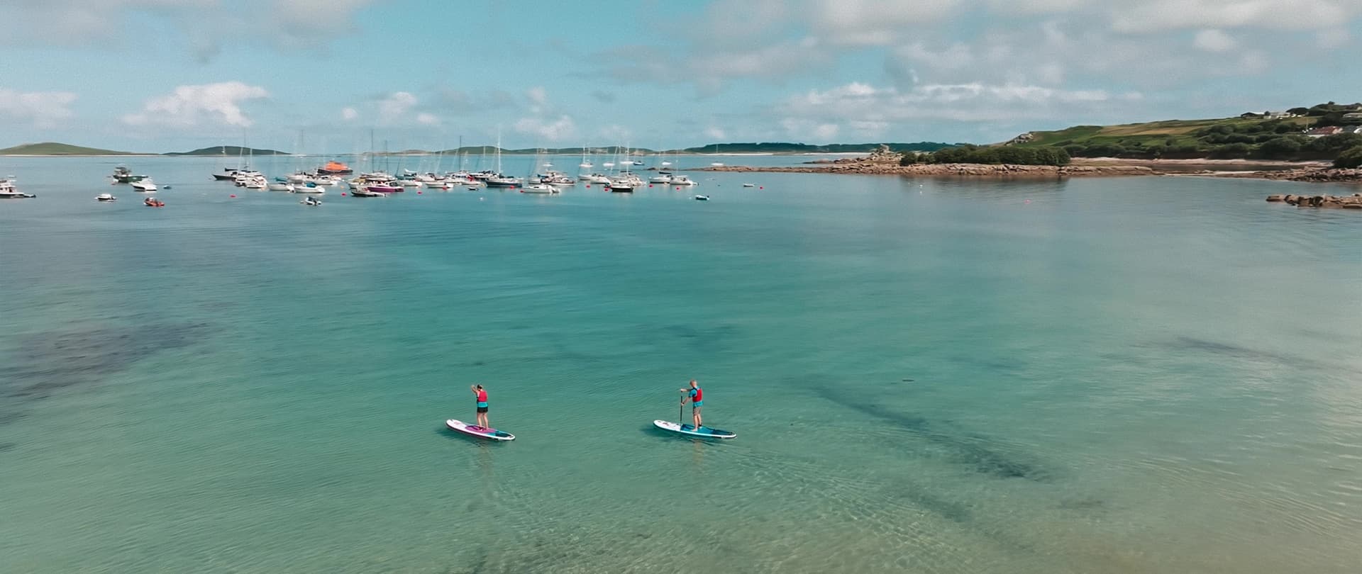Friends paddleboarding, Porthmellon, St Mary's, Isles of Scilly
