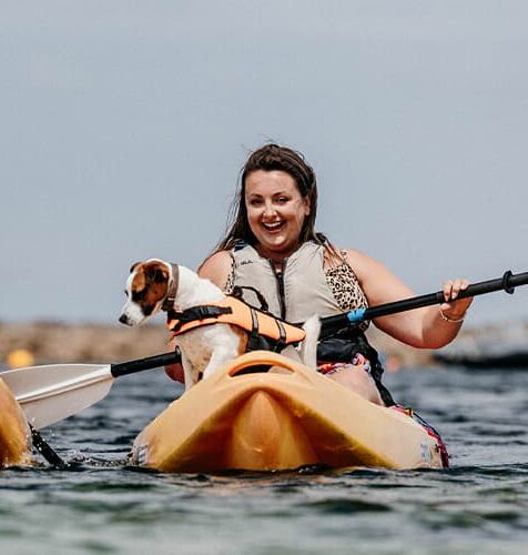 Woman kayaking with dog, St Agnes, Isles of Scilly