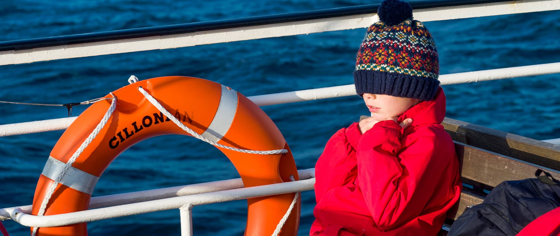 Child sitting outside on Scillonian III ferry