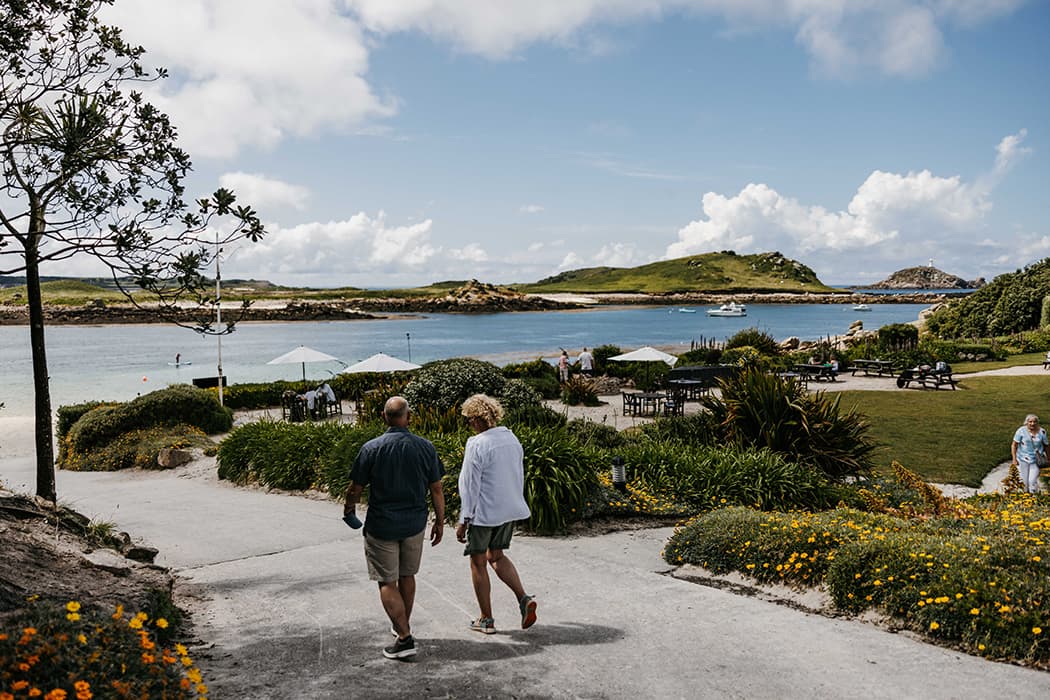 Couple walking through the garden at Karma St Martin's Hotel, Isles of Scilly
