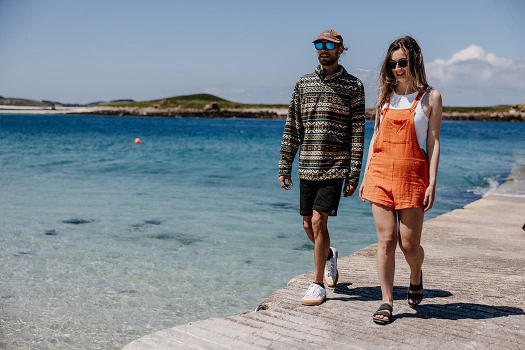 Couple walking up Lowertown quay, St Martin's, Isles of Scilly