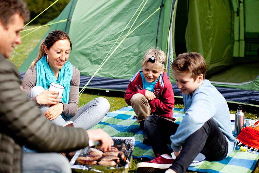 Family with their tent pitched at Garrison Holidays campsite, St Mary's, Isles of Scilly