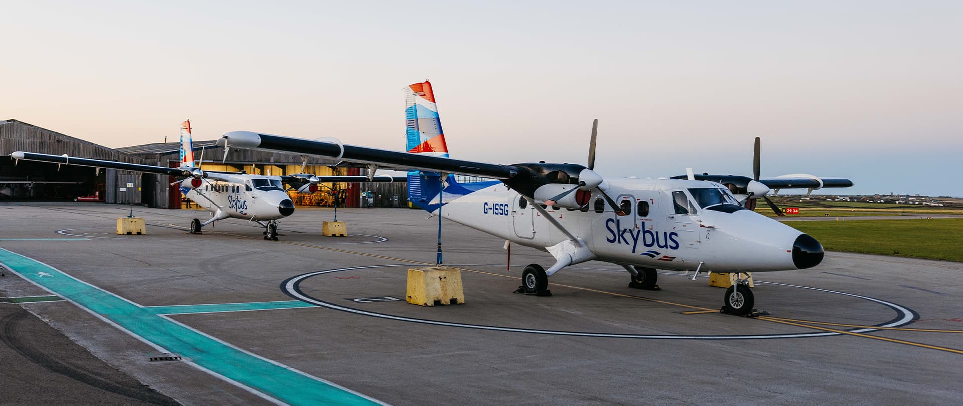 Two Skybus Twin Otter aircraft on the airfield early in the morning at Land's End Airport