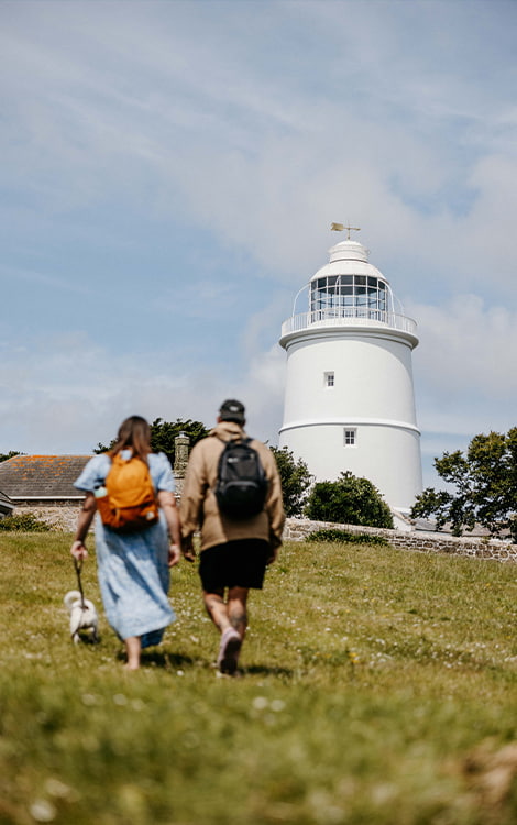 Couple walking with their dog to St Agnes Lighthouse