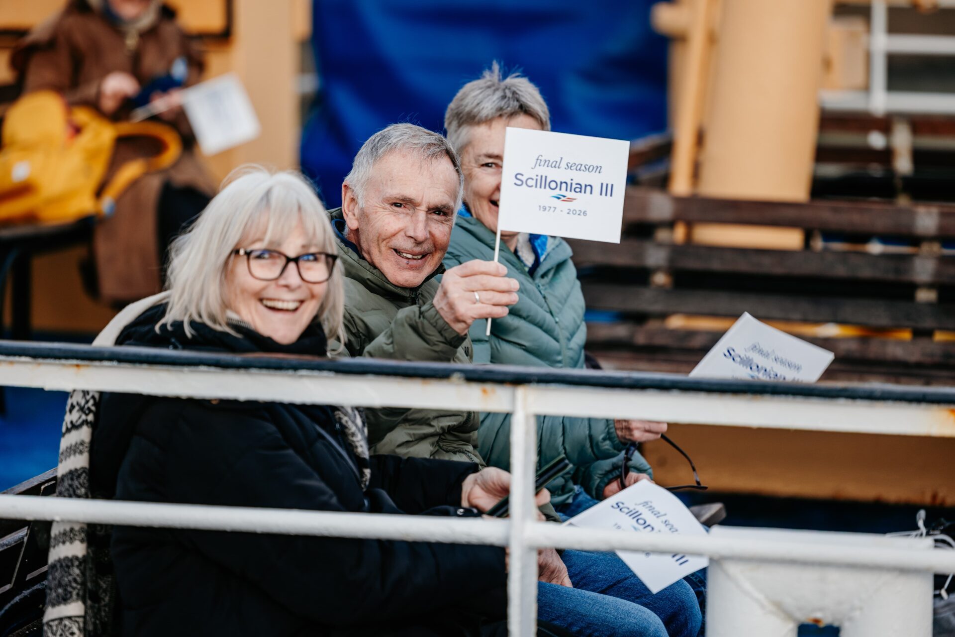 Passengers on Scillonian III's first sailing waving flags whilst sat on the deck