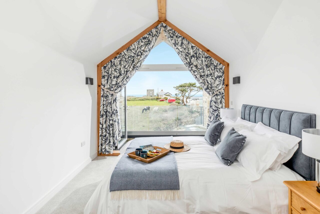 Bedroom at Chypraze with large windows looking out towards the gardens.
