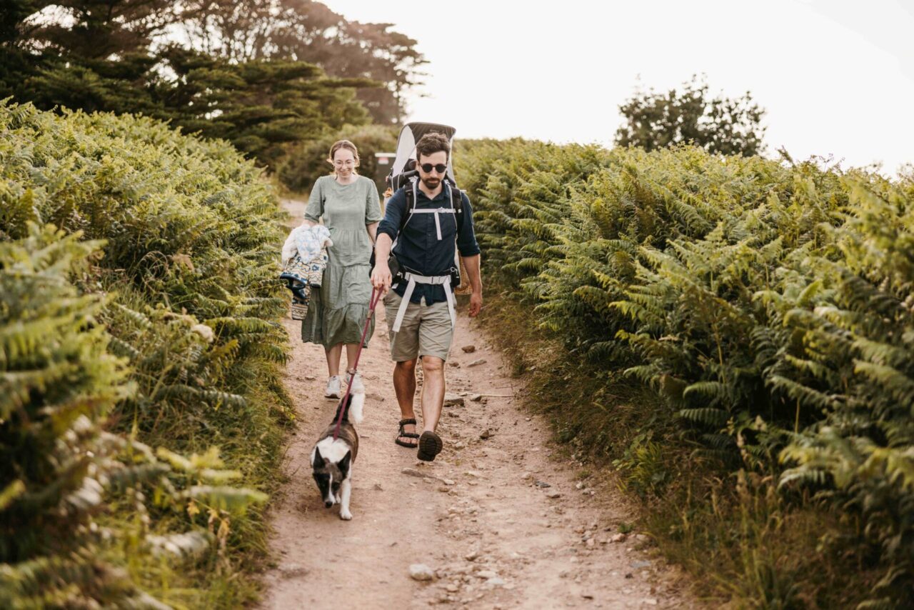 Couple, baby and dog walking along the coastal path