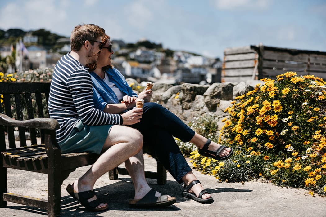 a couple eating ice cream on a bench in st mary's