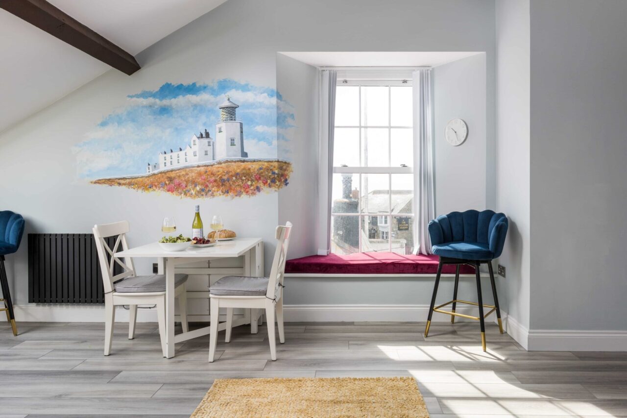 Living area at Lizard Lift at Trinity House, with light airy windows and dining area.